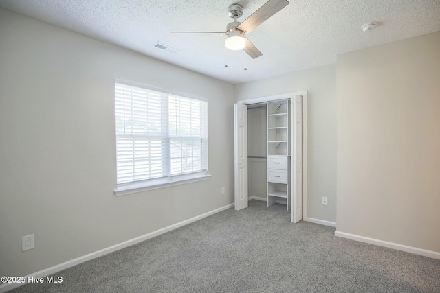 unfurnished bedroom with ceiling fan, a closet, carpet, and a textured ceiling