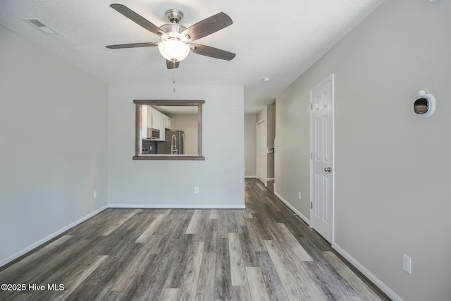 spare room featuring ceiling fan, hardwood / wood-style floors, and a textured ceiling