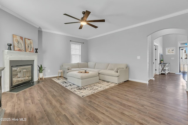 living room with hardwood / wood-style flooring, ceiling fan, and crown molding