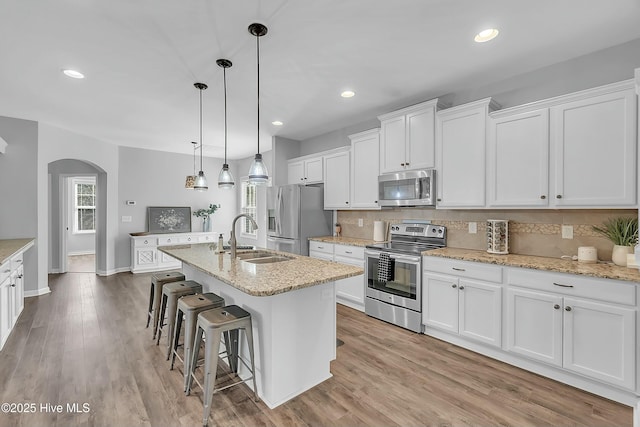 kitchen featuring an island with sink, appliances with stainless steel finishes, sink, and white cabinets