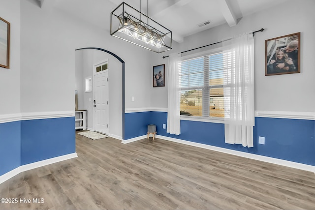 unfurnished room with beamed ceiling and wood-type flooring