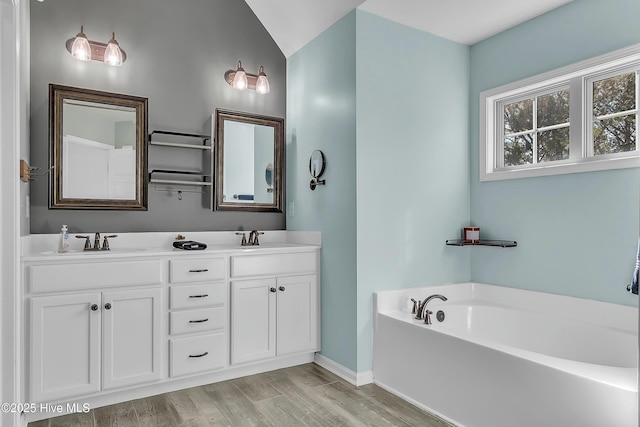 bathroom featuring hardwood / wood-style flooring, vanity, and a bathing tub