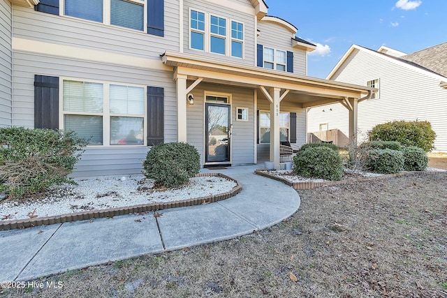 view of exterior entry featuring covered porch