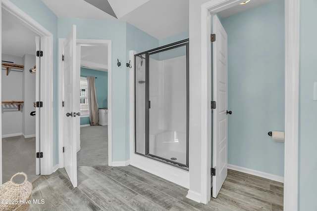 bathroom with a shower with shower door and wood-type flooring