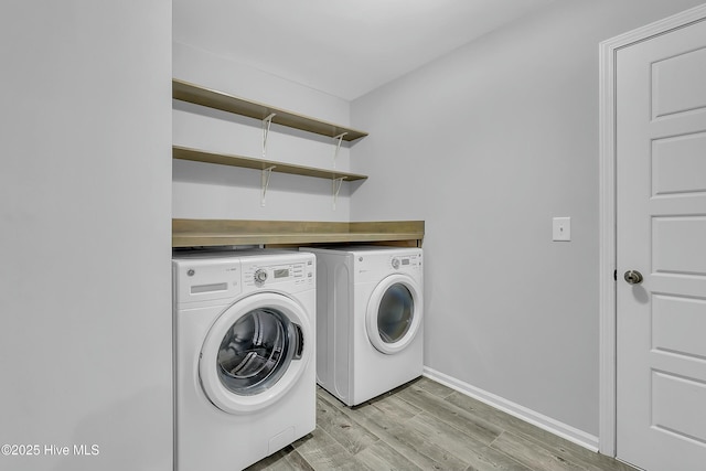 laundry room featuring independent washer and dryer and light hardwood / wood-style floors