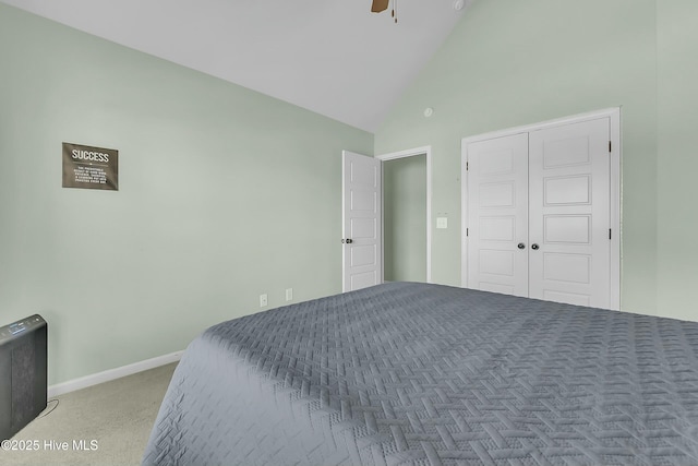 carpeted bedroom with ceiling fan, high vaulted ceiling, and a closet