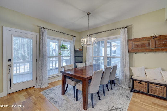 dining space with a notable chandelier and light hardwood / wood-style flooring