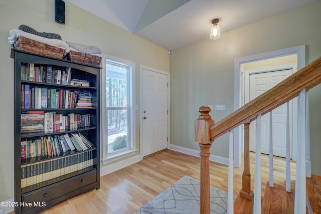 entryway with lofted ceiling, a healthy amount of sunlight, and light hardwood / wood-style floors