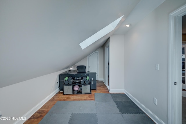 bonus room featuring dark hardwood / wood-style floors and lofted ceiling with skylight