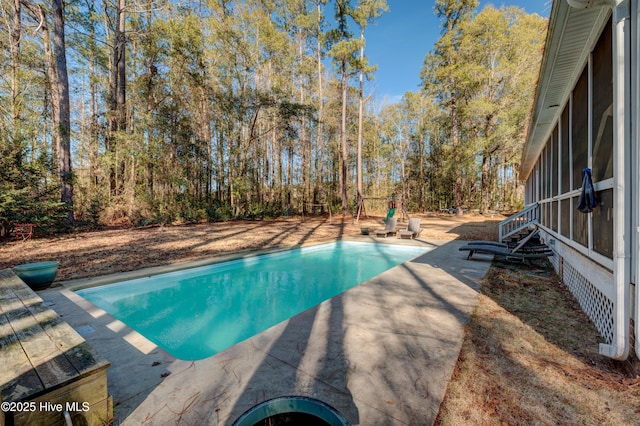 view of pool with a sunroom and a patio