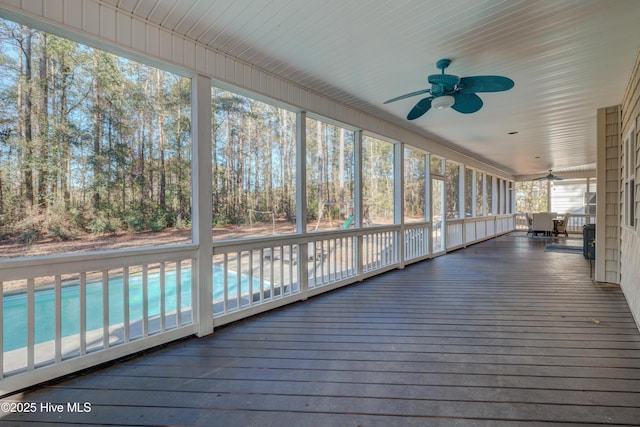 unfurnished sunroom with ceiling fan