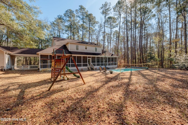 back of house featuring a playground and a sunroom