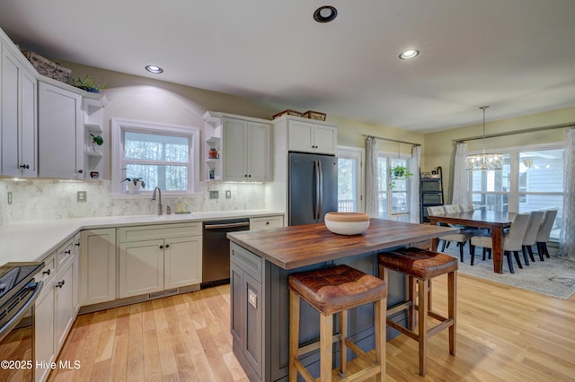 kitchen with white cabinetry, stainless steel refrigerator, and black dishwasher