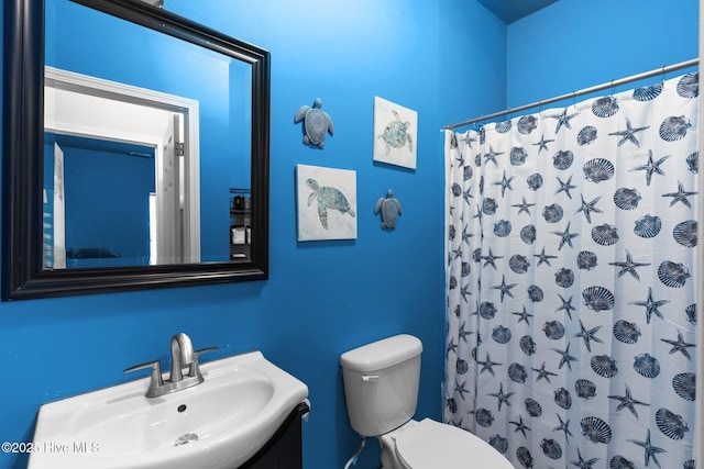 bathroom featuring sink, toilet, and walk in shower