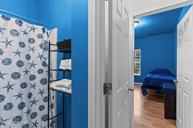 bathroom with hardwood / wood-style floors and curtained shower