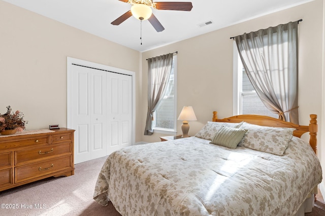 carpeted bedroom featuring ceiling fan and a closet