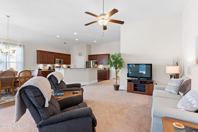 carpeted living room with lofted ceiling and ceiling fan with notable chandelier