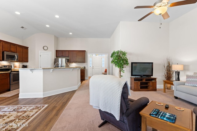 living room with lofted ceiling, dark hardwood / wood-style flooring, and ceiling fan