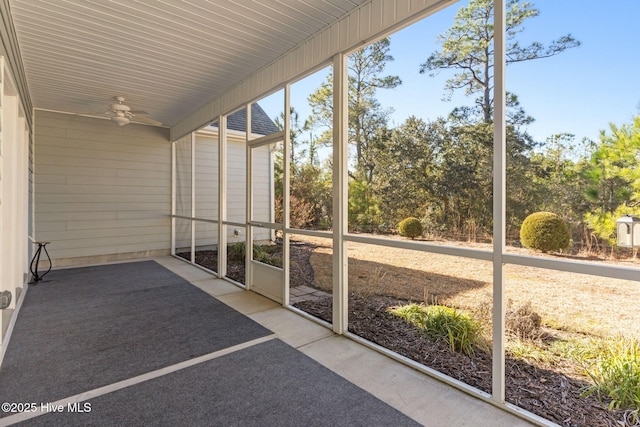 unfurnished sunroom with ceiling fan