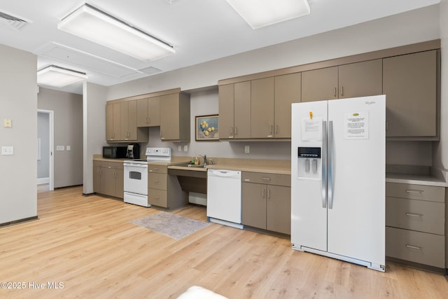 kitchen with sink, white appliances, and light wood-type flooring