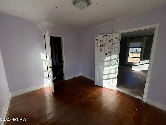 empty room featuring crown molding and dark wood-type flooring