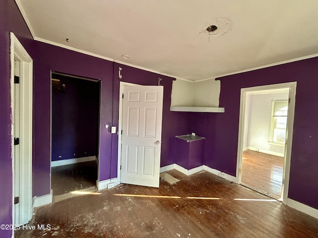 unfurnished bedroom with ornamental molding and dark hardwood / wood-style floors