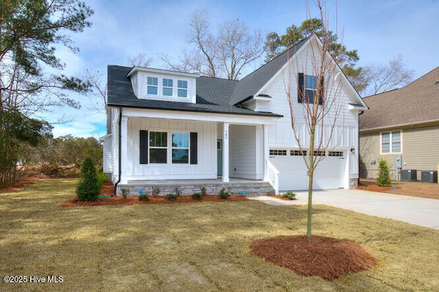 view of front of house with a garage, concrete driveway, a porch, board and batten siding, and a front yard