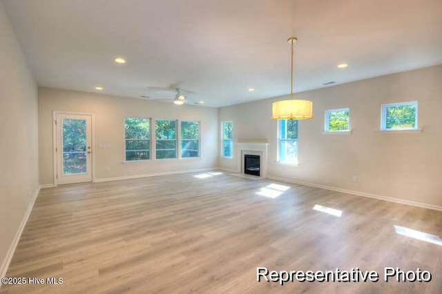 unfurnished living room with ceiling fan and light hardwood / wood-style floors