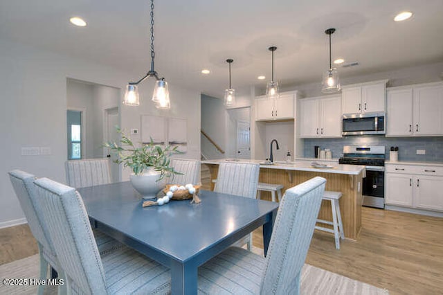 dining space with light wood-type flooring, baseboards, and recessed lighting