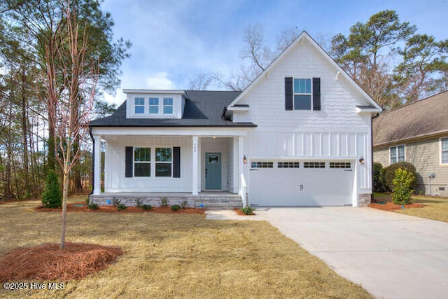 view of front facade with a porch, a garage, driveway, a front lawn, and board and batten siding