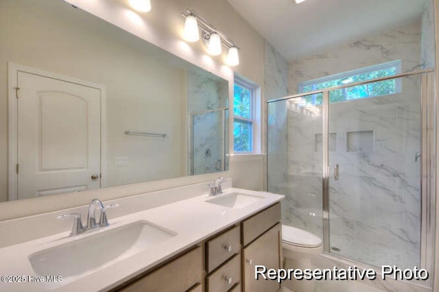 bathroom featuring vanity, toilet, and a shower with shower door