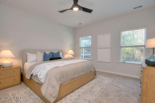 bedroom with baseboards, multiple windows, visible vents, and light colored carpet