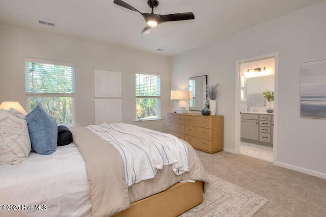 bedroom featuring visible vents, baseboards, a ceiling fan, connected bathroom, and light colored carpet