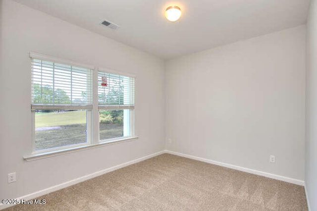 spare room featuring carpet floors, baseboards, and visible vents