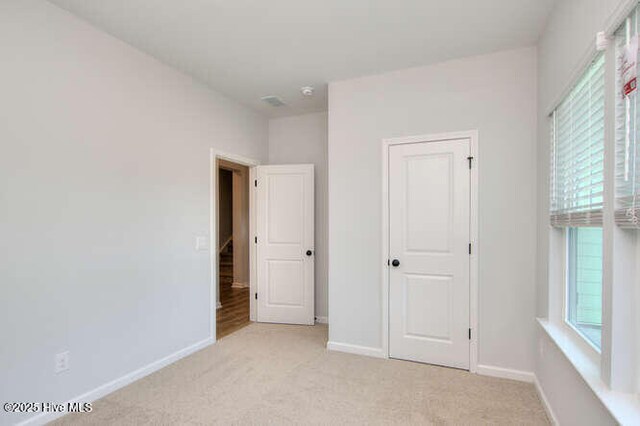 unfurnished room featuring light colored carpet