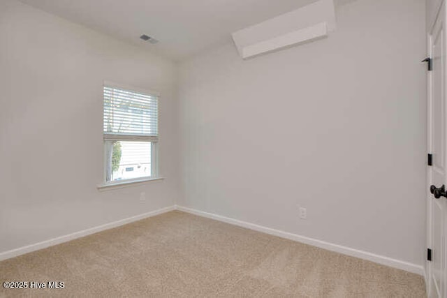 carpeted spare room featuring baseboards