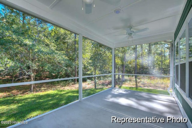 unfurnished sunroom with ceiling fan