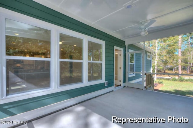 unfurnished sunroom featuring ceiling fan