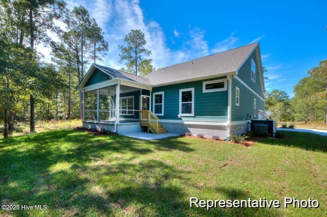 rear view of property featuring a sunroom and a lawn