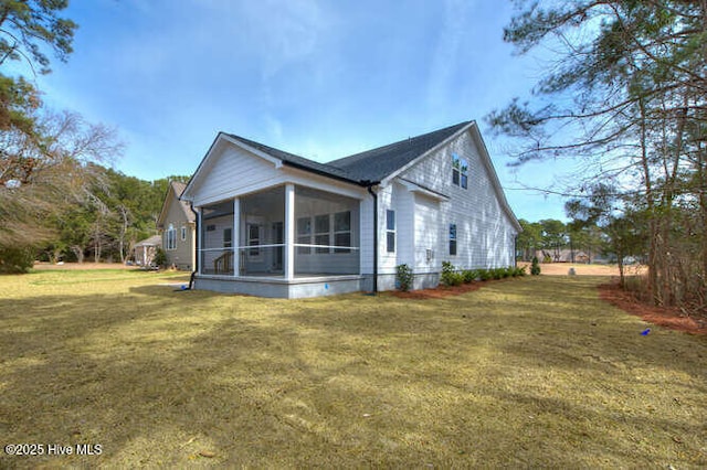 view of property exterior featuring a sunroom and a lawn