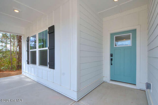 entrance to property featuring a porch and board and batten siding