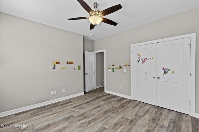 unfurnished bedroom with ceiling fan, a closet, and light hardwood / wood-style flooring