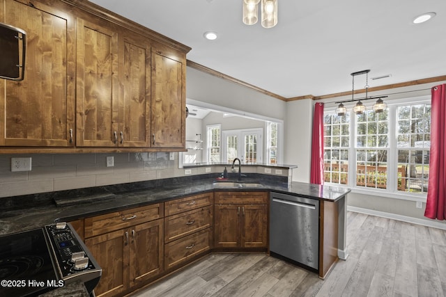 kitchen with pendant lighting, dishwasher, sink, dark stone counters, and kitchen peninsula