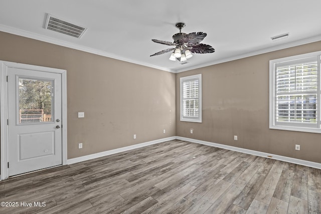 unfurnished room featuring crown molding, ceiling fan, plenty of natural light, and hardwood / wood-style floors