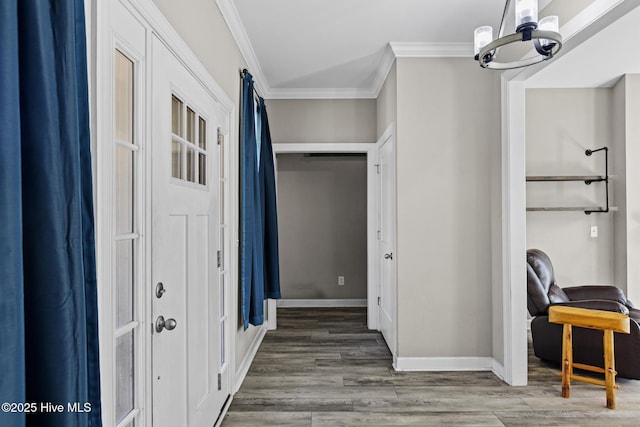 interior space with an inviting chandelier, wood-type flooring, and ornamental molding