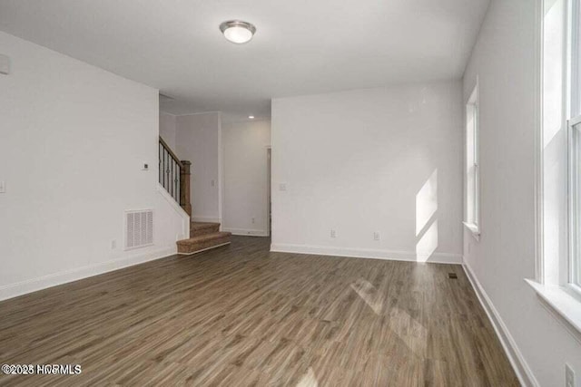 unfurnished living room with dark wood-type flooring