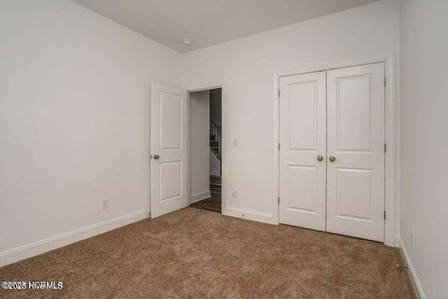 unfurnished bedroom featuring carpet floors and a closet