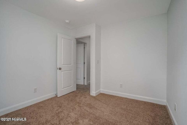 spare room featuring light carpet