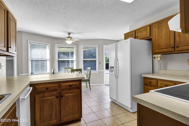 kitchen with white fridge with ice dispenser, stainless steel dishwasher, light tile patterned floors, ceiling fan, and a textured ceiling