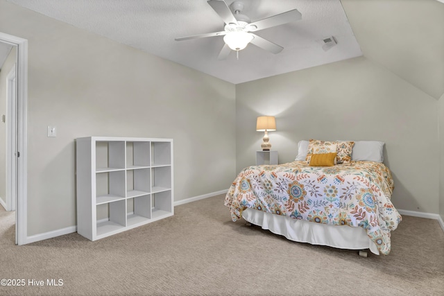 carpeted bedroom featuring ceiling fan, vaulted ceiling, and a textured ceiling